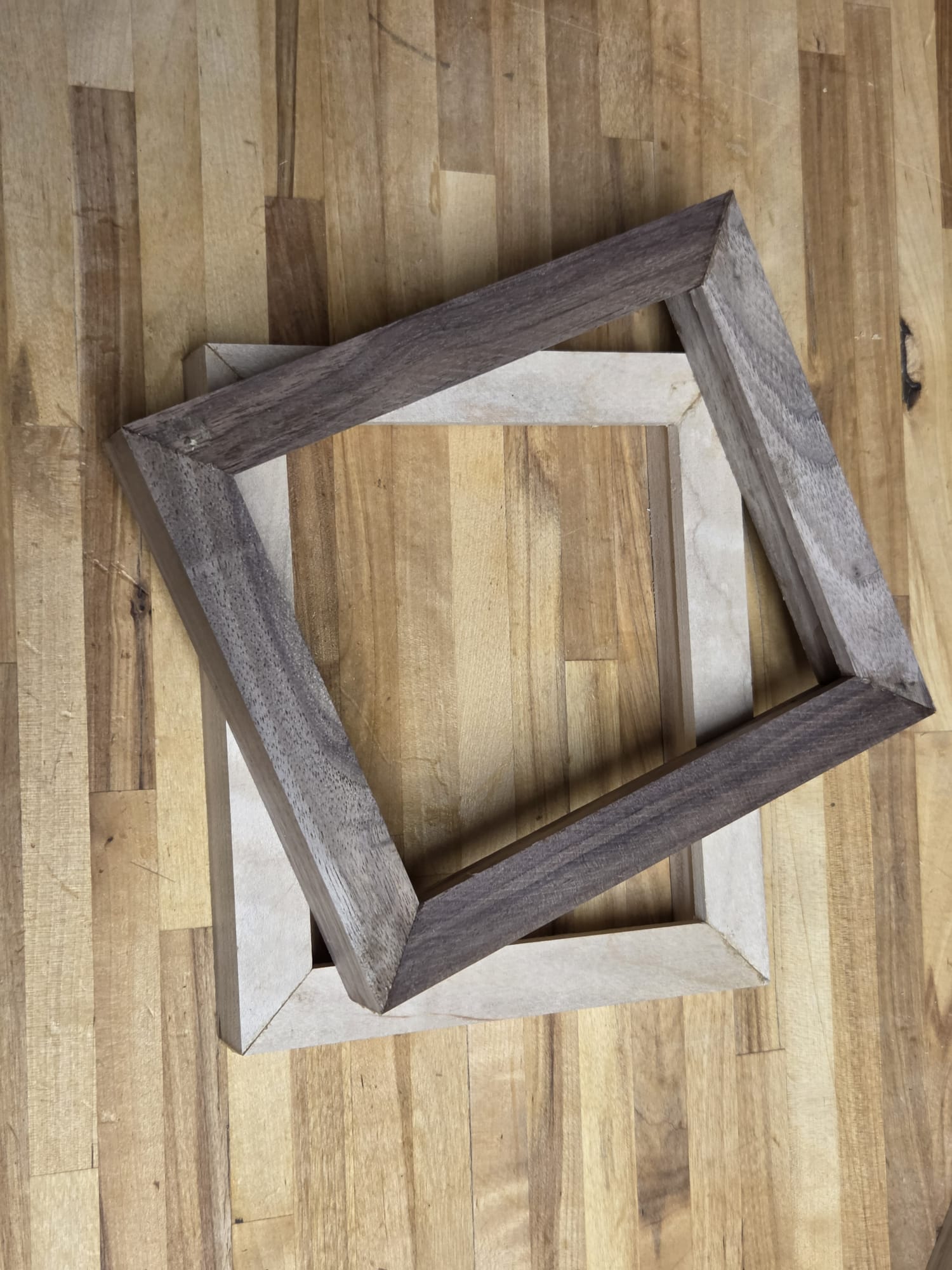 Oak and Walnut handmade frames stacked on the Resonoak workshop bench